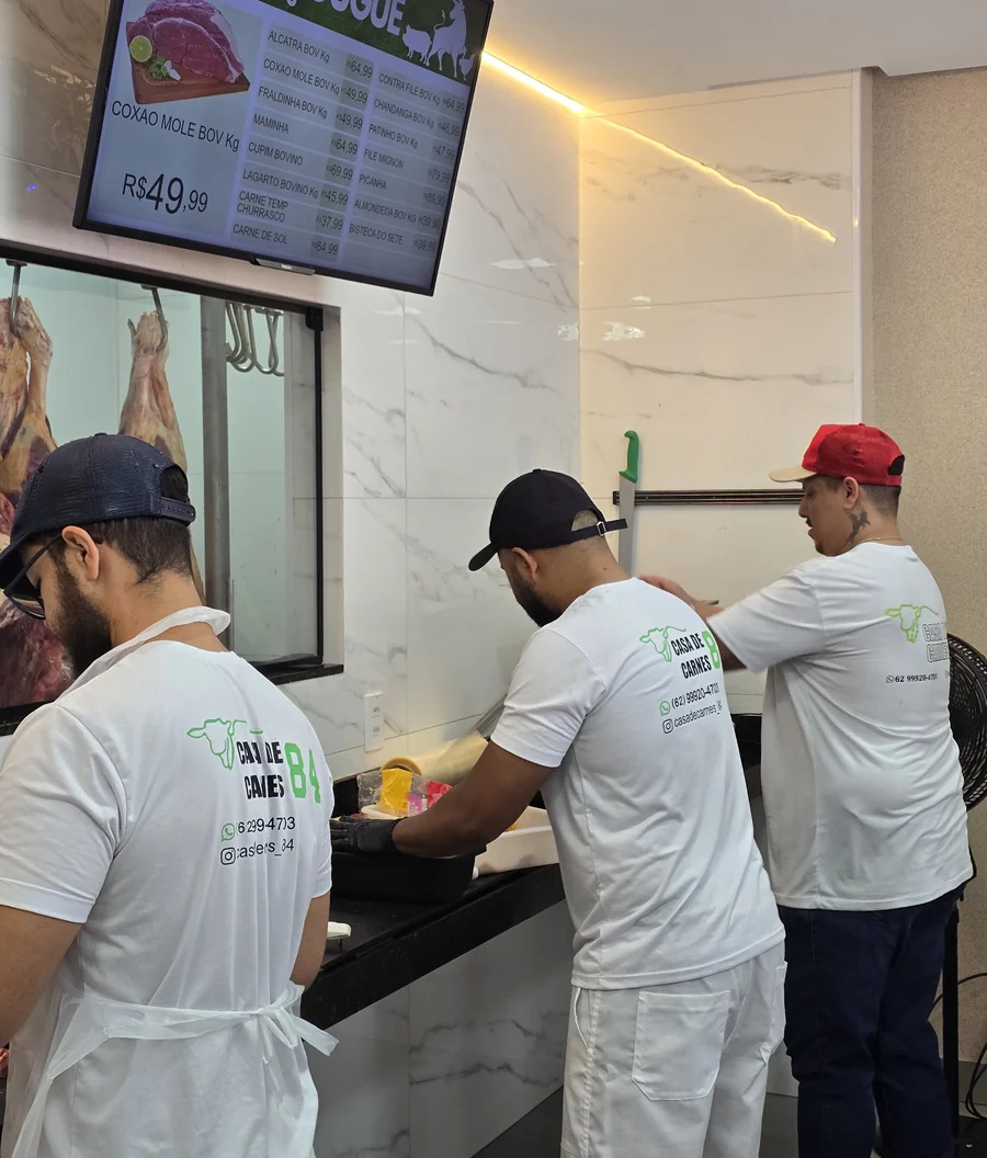 Açougueiros da Casa de Carnes 84 preparando as carnes